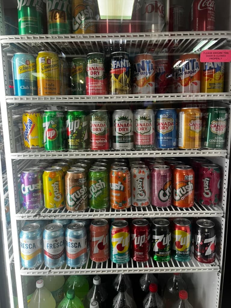 A convenience-store fridge stocked with citrus and zero-sugar sodas